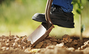 Construction Craft Laborer digging a utility hole.